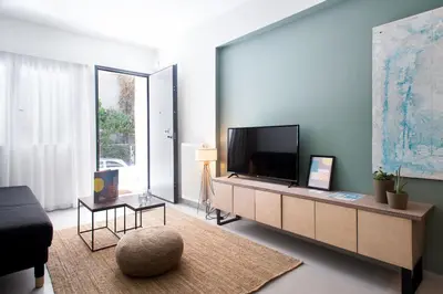 a living room with a flat screen tv and a couch at Soho Apartments by Olala Homes in Athens