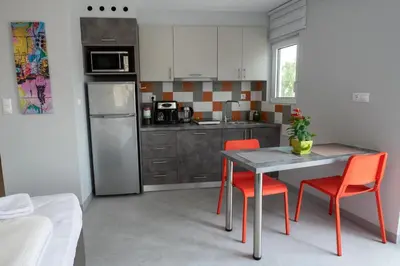 a kitchen with a table and two orange chairs at Acropolis Monastiraki Newly Renovated Apartment in Athens