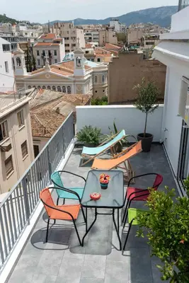a patio with chairs and tables on a balcony at Acropolis Monastiraki Newly Renovated Apartment in Athens
