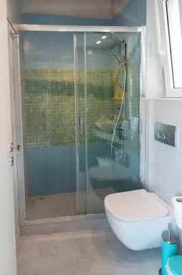 a bathroom with a glass shower with a toilet at Acropolis Monastiraki Newly Renovated Apartment in Athens