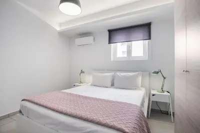 a white bedroom with a bed and a window at Supreme C1 Apartment in Syntagma in Athens