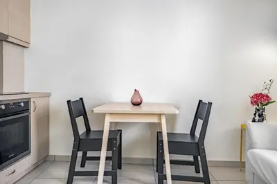 a small table with two chairs and a vase on it at Supreme C1 Apartment in Syntagma in Athens