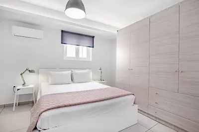 a white bedroom with a large bed with white cabinets at Supreme C1 Apartment in Syntagma in Athens