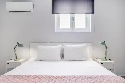 a bedroom with a white bed with two night stands at Supreme C1 Apartment in Syntagma in Athens
