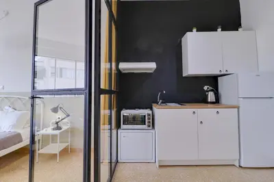a room with a bed and a white refrigerator at athens.apartotel.1 in Athens