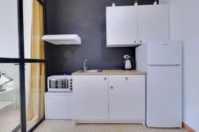 a kitchen with white cabinets and a microwave at athens.apartotel.1 in Athens