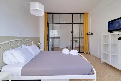 a bedroom with a large bed and a tv at athens.apartotel.1 in Athens