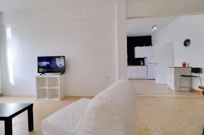 a white living room with a white couch and a table at athens.apartotel.1 in Athens