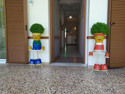 two potted plants in front of a door at Finikas Rooms in Agia Marina Aegina