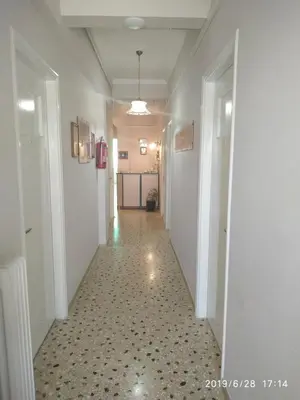 a hallway with a long corridor with white walls at Finikas Rooms in Agia Marina Aegina