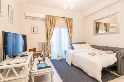 a bedroom with a bed and a desk and a television at Iris apartment acropolis terrace view in Athens