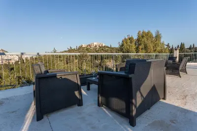 two chairs and a table on a patio at Iris apartment acropolis terrace view in Athens