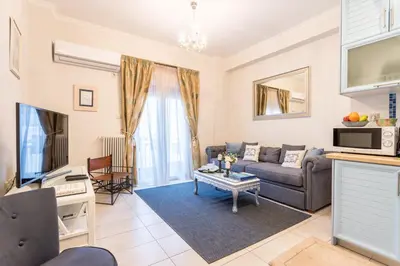 a living room with a couch and a tv at Iris apartment acropolis terrace view in Athens