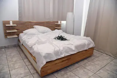 a bed with white sheets and a plant on it at Best of Athens Apartment in Athens