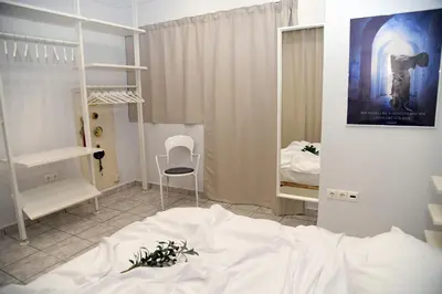 a bedroom with a white bed and a chair at Best of Athens Apartment in Athens