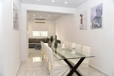 a dining room with a glass table and white chairs at Best of Athens Apartment in Athens