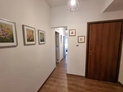 a hallway with a door and paintings on the wall at Stylish Urban Apartment by YHA in Athens