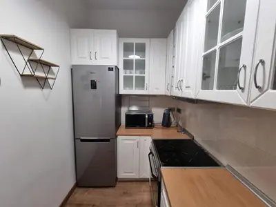 a kitchen with white cabinets and a stainless steel refrigerator at Stylish Urban Apartment by YHA in Athens