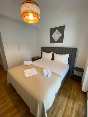 a bedroom with a large bed with two towels on it at Stylish Urban Apartment by YHA in Athens