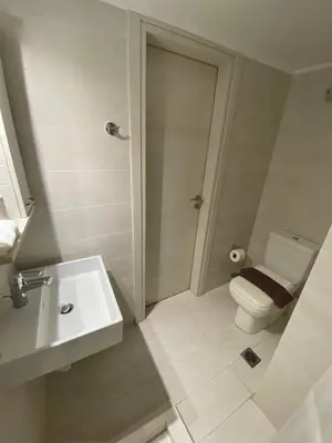 a white bathroom with a toilet and a sink at Stylish Urban Apartment by YHA in Athens