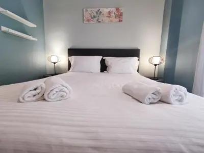 a bedroom with a white bed with towels on it at Stylish Urban Apartment by YHA in Athens
