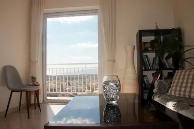 a living room with a glass vase on a table and a window at Penthouse with Sea View in Athens