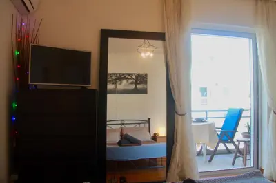 a room with a television and a living room with a couch at Penthouse with Sea View in Athens