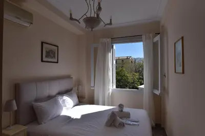 a doll sitting on a bed in a bedroom with a window at Acro&Polis in Athens
