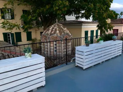 two white benches sitting in front of a fence at Acro&Polis in Athens