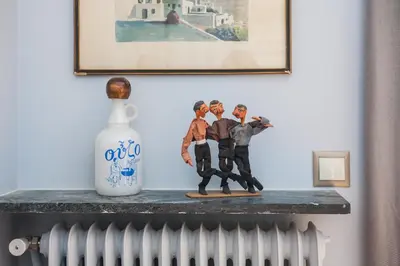 a figurine of three men on a shelf next to a vase at Athens Vintage Apartment - Ilisia in Athens