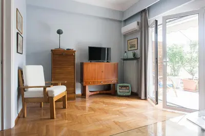 a living room with a tv and a chair at Athens Vintage Apartment - Ilisia in Athens