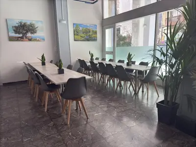 a row of tables and chairs in a room with plants at Paloma in Athens