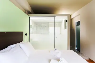 a bedroom with a white bed with two towels at Greece U Around Athens Thissio Suites in Athens
