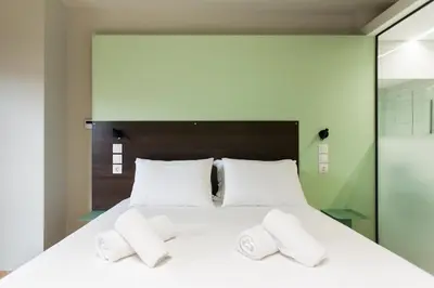 a bedroom with a large white bed with two pillows at Greece U Around Athens Thissio Suites in Athens