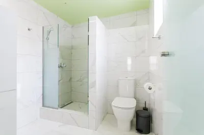 a white bathroom with a shower and a toilet at Greece U Around Athens Thissio Suites in Athens