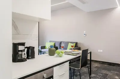 a kitchen with a counter with chairs and a table at Greece U Around Athens Thissio Suites in Athens