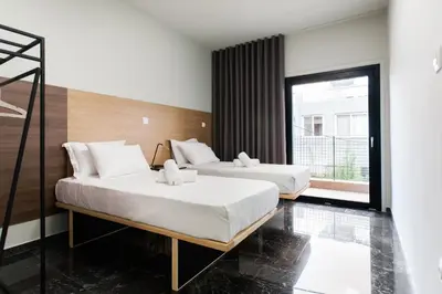 two beds in a room with a window at Greece U Around Athens Thissio Suites in Athens