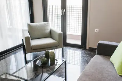 a living room with a couch and a chair and a table at Greece U Around Athens Thissio Suites in Athens