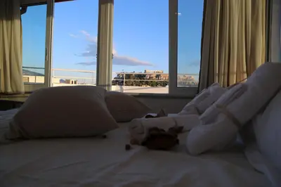 a bedroom with a bed with white sheets and pillows at Flat in Monastiraki with stunning view of Acropolis in Athens