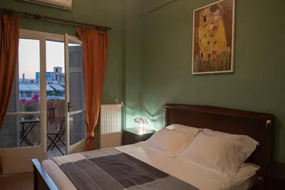 a bedroom with a bed and a door to a balcony at Mosaics Astonishing Acropolis view Aprtm in Athens