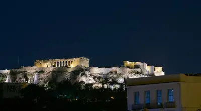 a building on top of a mountain at night at Thission Luxury Homes & SPA by K&K in Athens