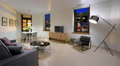a living room with a couch and a table and a tv at Thission Luxury Homes & SPA by K&K in Athens