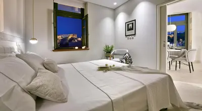 a white bedroom with a large bed and a dining room at Thission Luxury Homes & SPA by K&K in Athens