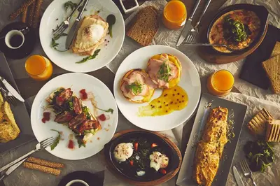 a table topped with plates of food and oranges at The Artist Athens in Athens