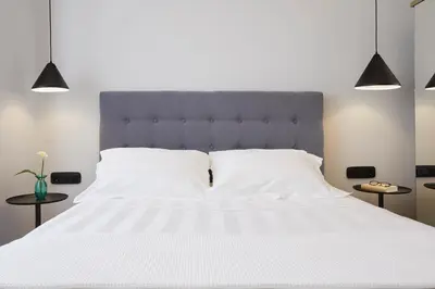 a bedroom with a large white bed with two tables at The Artist Athens in Athens