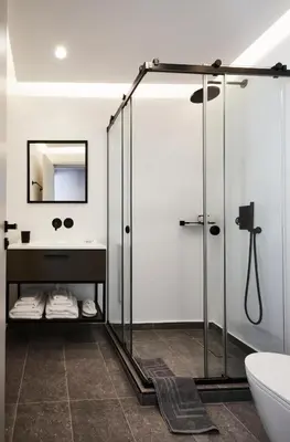a bathroom with a glass shower and a sink at The Artist Athens in Athens