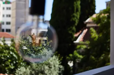 a wine glass with a reflection of a building in it at The Artist Athens in Athens