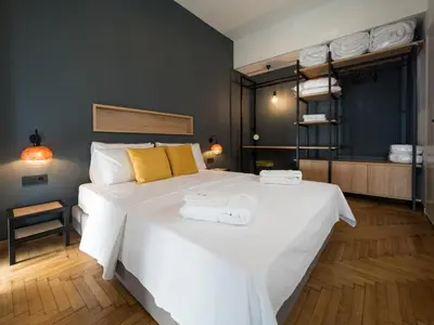 a bedroom with a large white bed with towels on it at Luxury Veni Acropolis View Apartment in Athens