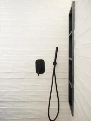a shower with a black hose attached to a wall at Luxury Veni Acropolis View Apartment in Athens