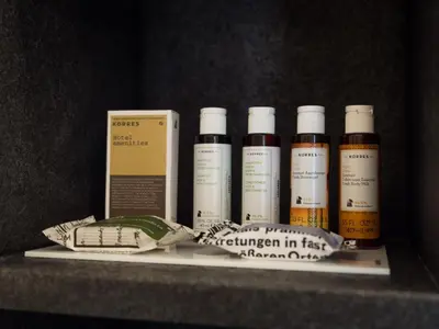 a shelf with four bottles of oil and a box at Luxury Veni Acropolis View Apartment in Athens